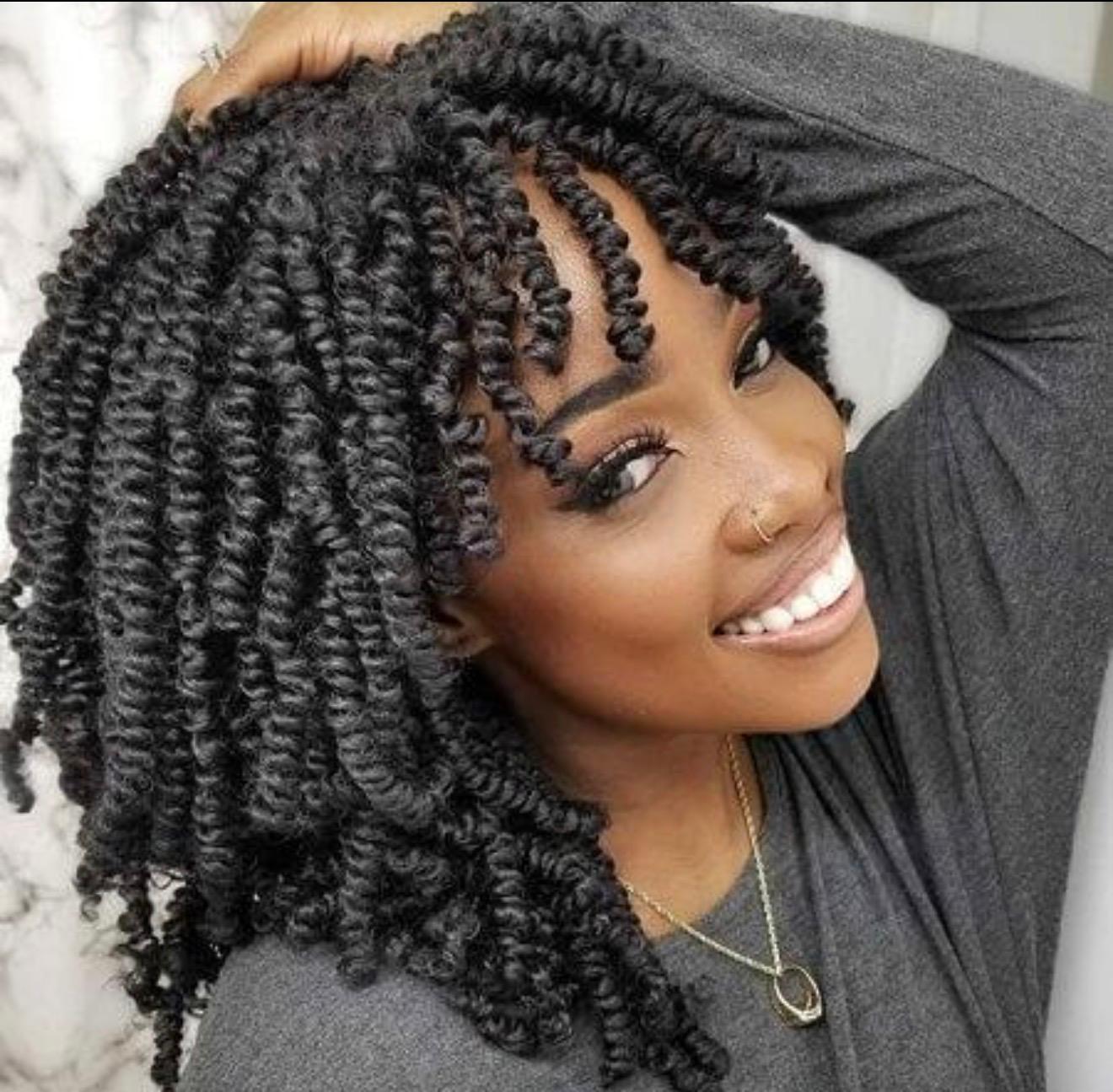 Voluminous natural spring twists with defined coils on a smiling client