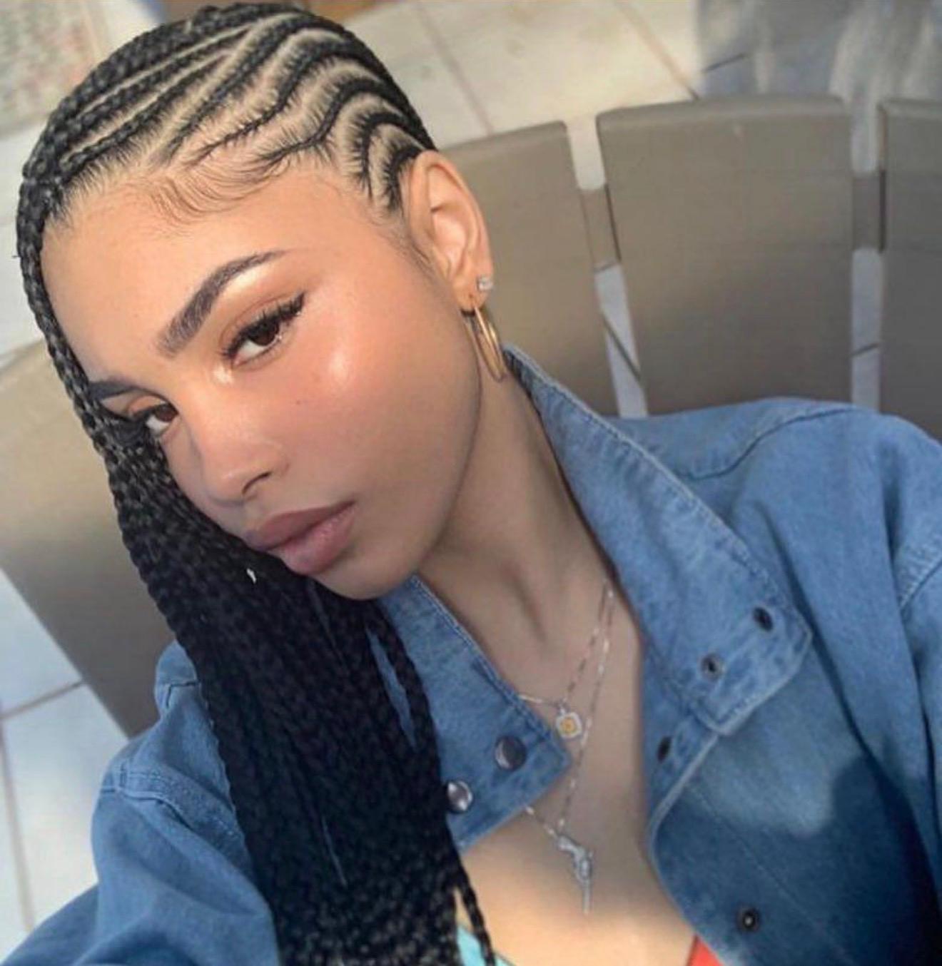 Small feed-in fulani cornrows with curved side parts and laid baby hairs in a denim jacket