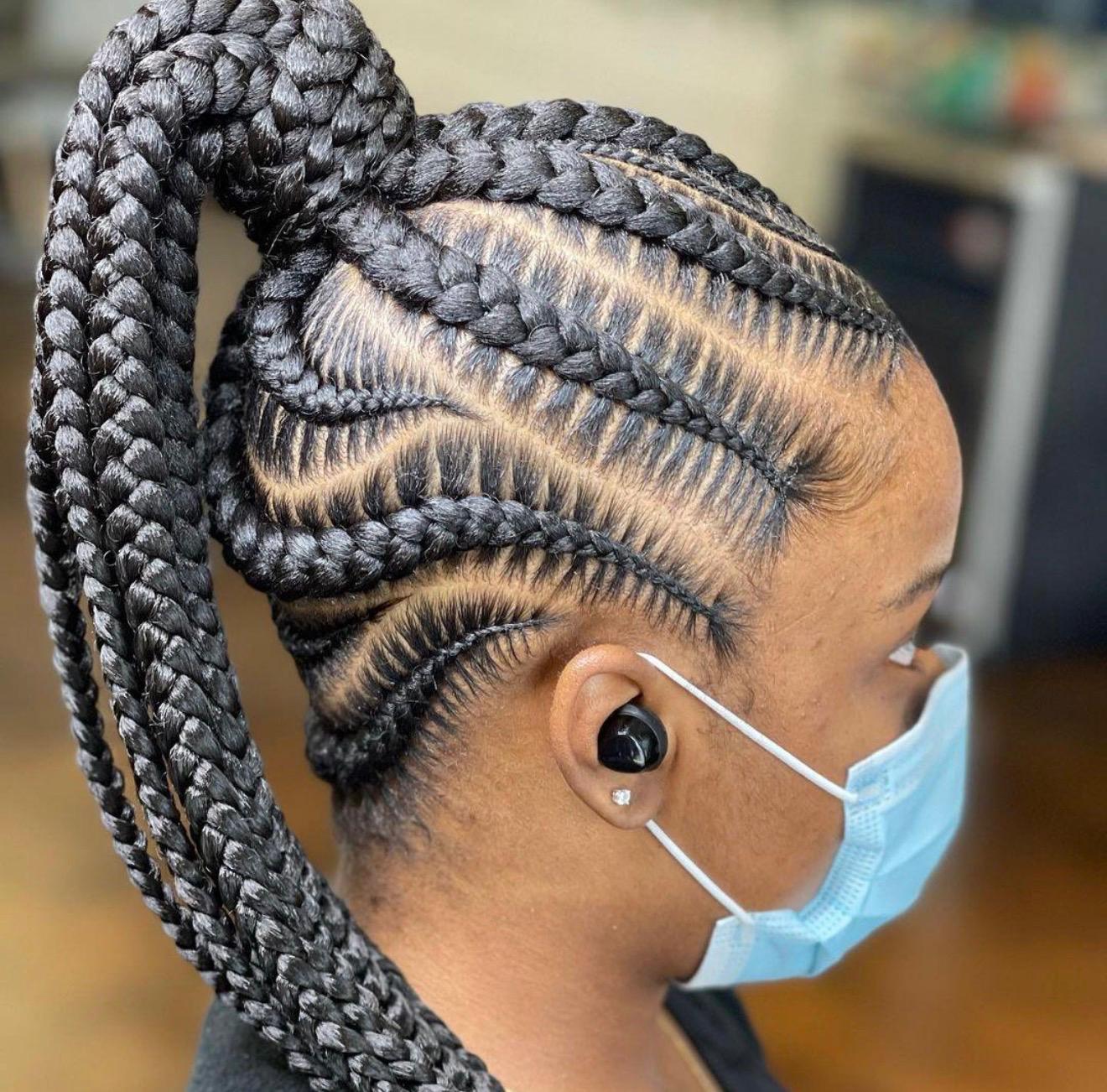 High feed-in cornrow ponytail with sleek stitch parts and a jumbo braided drape