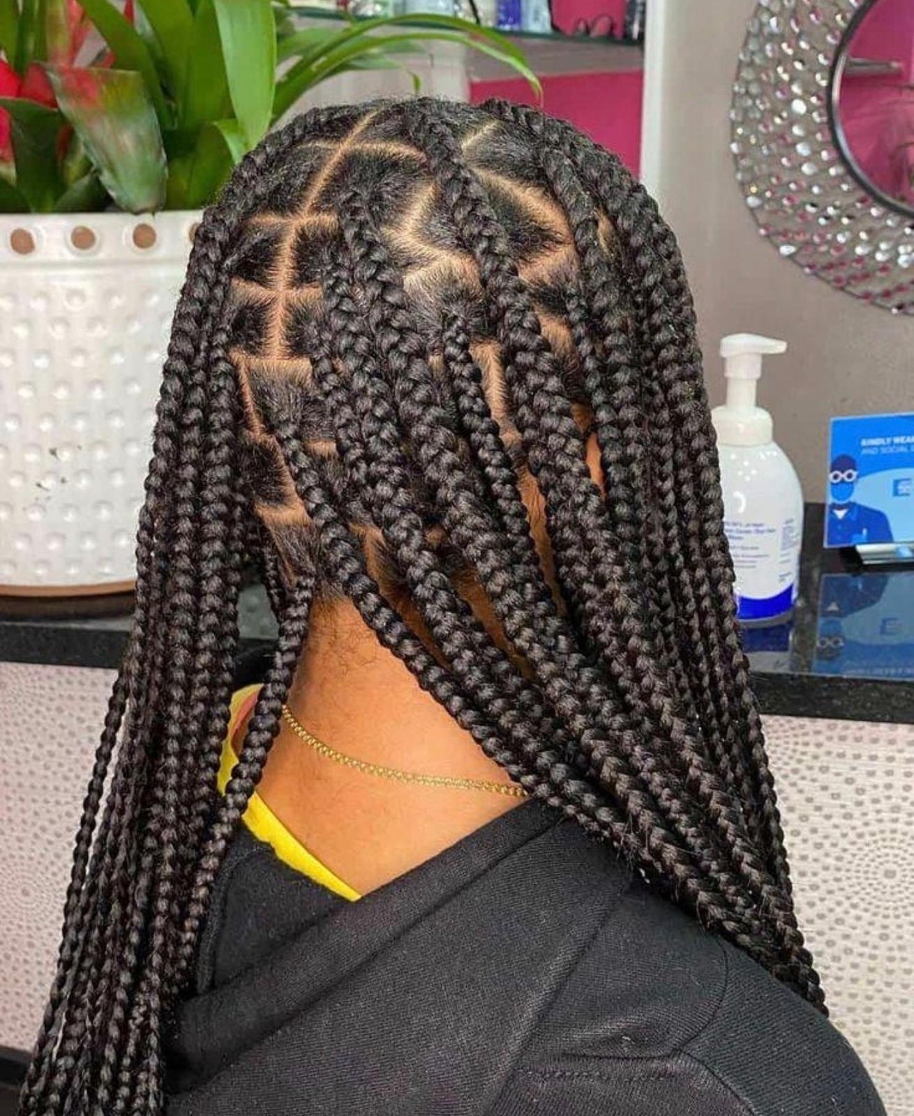 Back view of medium knotless box braids with clean diamond parts and neat gel-set roots